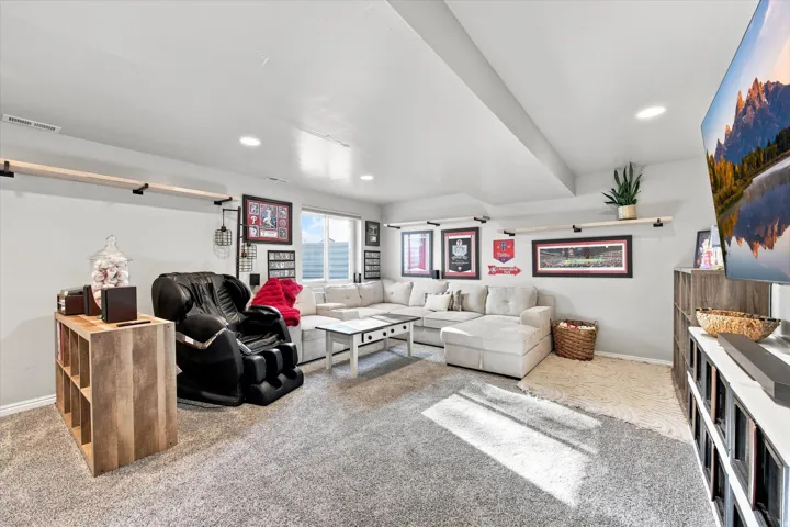 Recessed lighting, light gray carpet, window with natural light, built-in shelving, and floating wood shelves