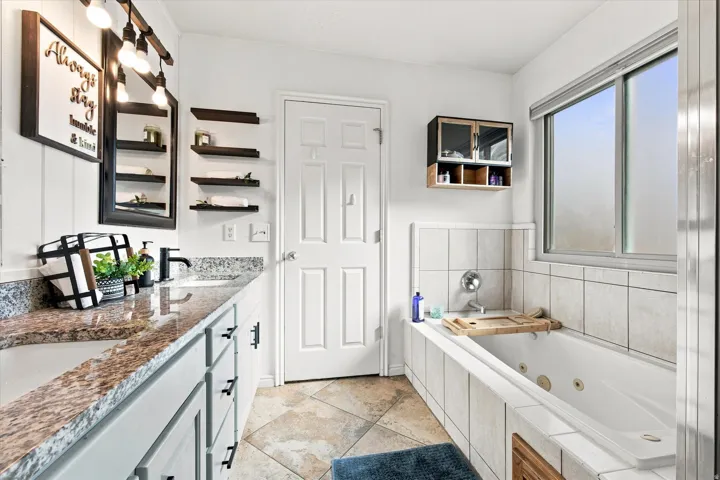 Dual vanity with granite countertops, integrated drop-in sinks, and matte black fixtures