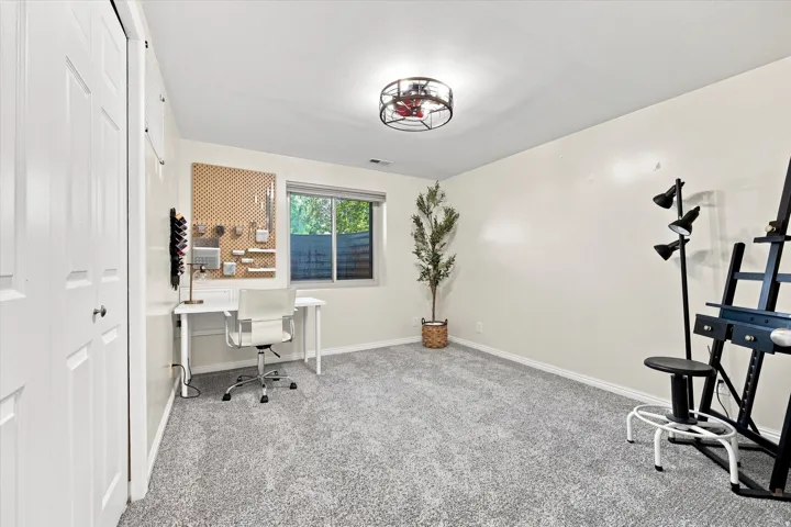 Neutral wall color, wall-to-wall carpeting, window with natural light, bi-fold closet doors, and a ceiling-mounted light fixture