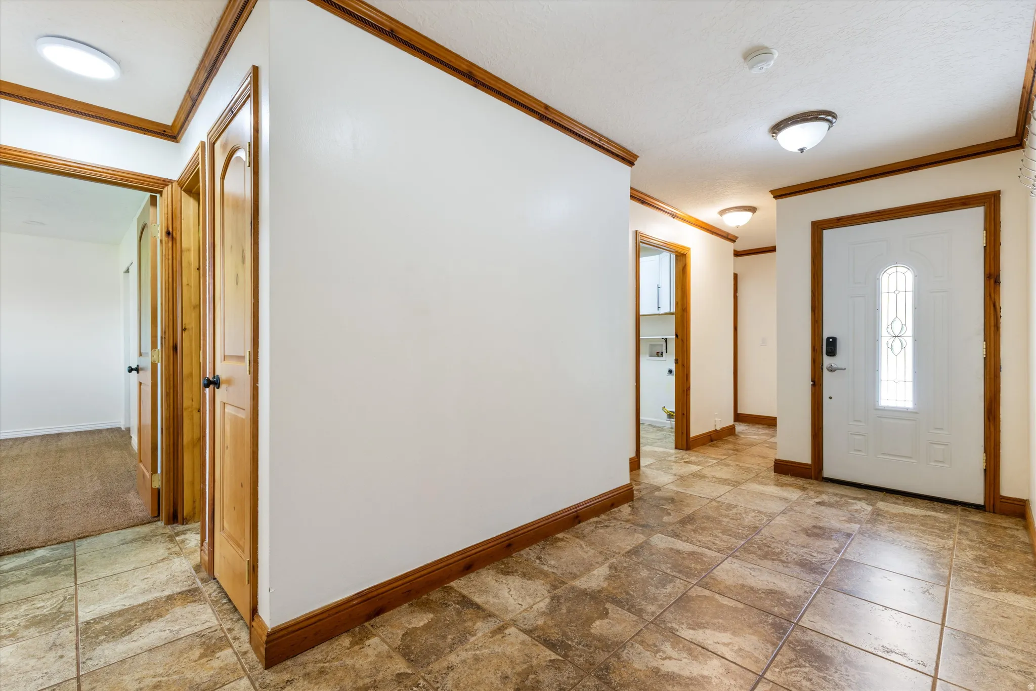 Entryway featuring tile flooring, wood-finish trim, and recessed lighting