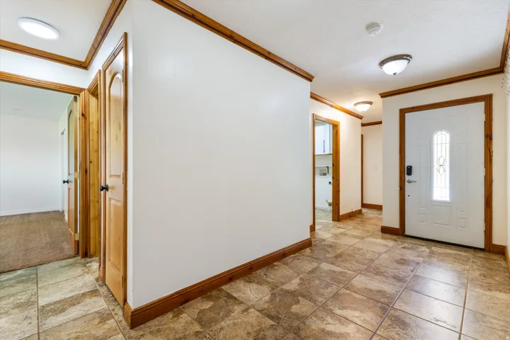 Entryway featuring tile flooring, wood-finish trim, and recessed lighting