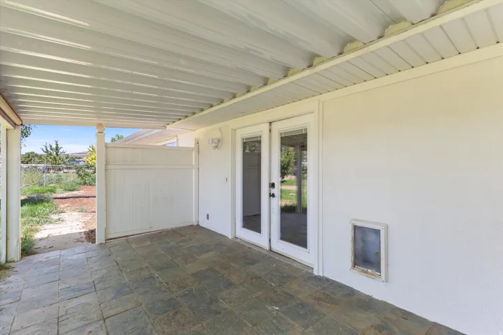 Covered patio featuring slate-style tile flooring and direct exterior access through French doors