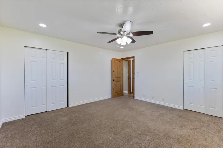 Recessed lighting, ceiling fan light fixture, wood-finish interior door, and dual sliding closet doors