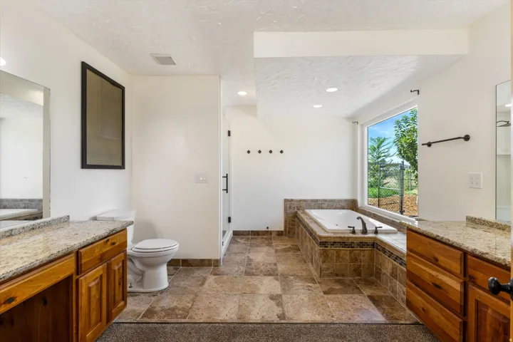 Dual wood-finish vanities with light stone countertops and integral sinks