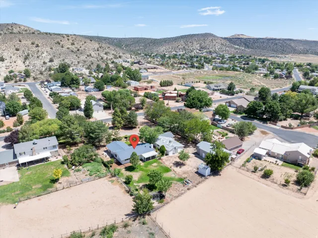 Property situated on a street with mature trees and surrounding arid hills