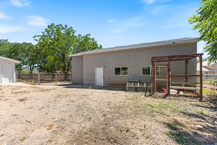 Stucco exterior structure with multiple windows and a white entry door