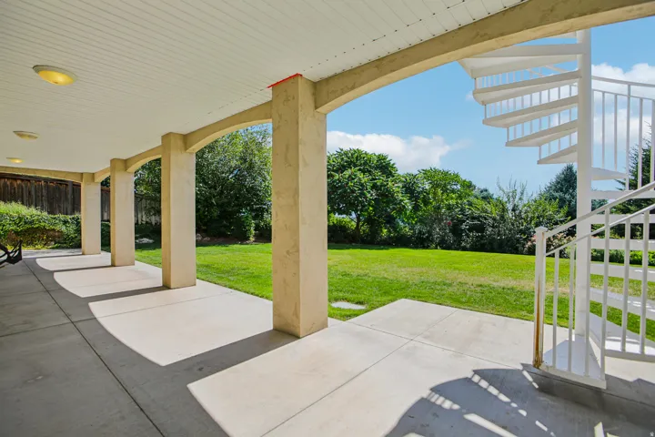 Covered patio with arched columns and a concrete surface