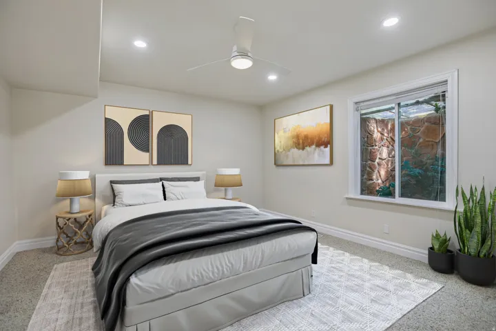 Recessed lighting, ceiling fan, window with stone exterior, and light-colored carpeting