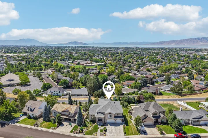 Aerial perspective showcasing the residential neighborhood with distant mountains and a body of water