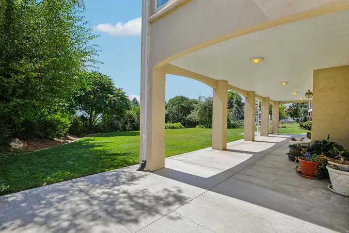 Expansive covered patio with arched columns and recessed lighting