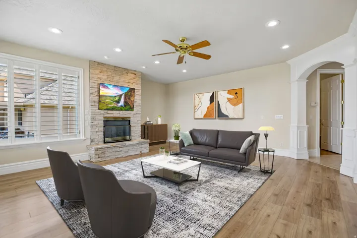 Wood-finish flooring, recessed lighting, and a stone-clad fireplace