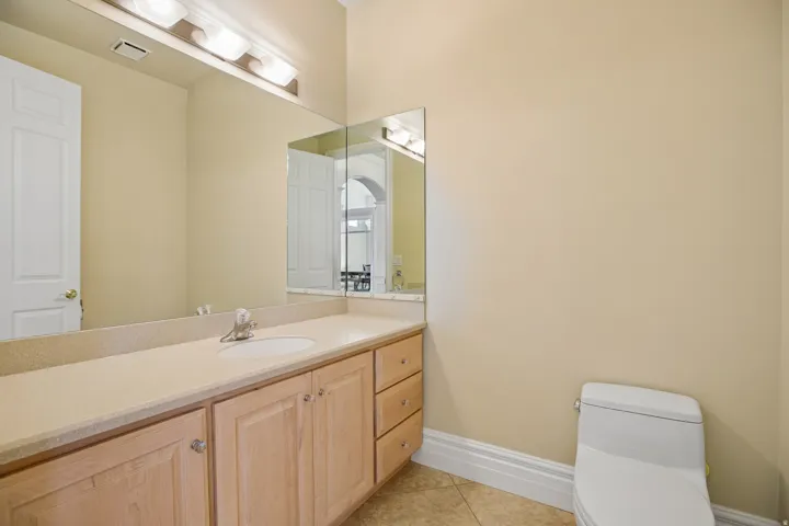 Vanity with light-toned cabinetry, a spacious countertop, and an integrated sink