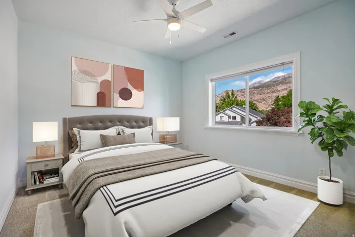 Ceiling fan, window with mountain scenery, carpet flooring, and light blue wall finish