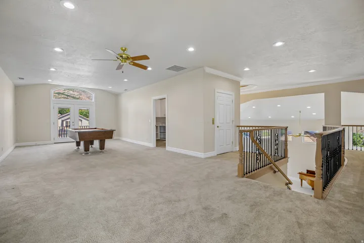 Arched double doors, recessed lighting, ceiling fan, and carpeted flooring