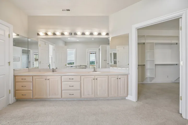Double vanity with two integrated sinks, extensive countertop space, and under-cabinet storage