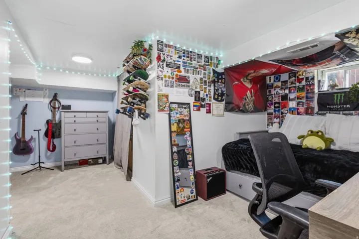 Plush carpet flooring, recessed ceiling lighting, and a window providing natural light