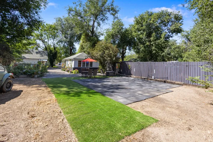 Backyard featuring a privacy fence, covered patio area, and a grass section