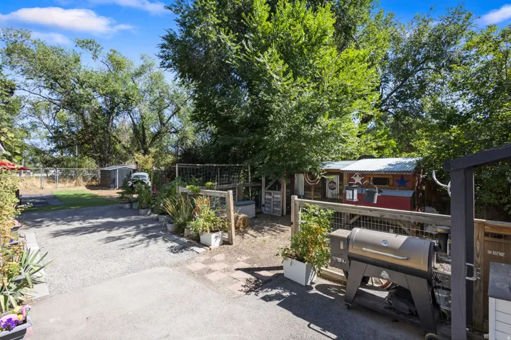 Expansive outdoor space featuring a graveled area, paved sections, and a wood-fenced enclosure
