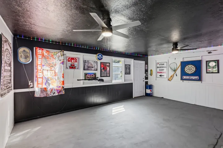 Party Shed. Enclosed versatile space featuring a concrete floor, dark textured ceiling, and white paneling
