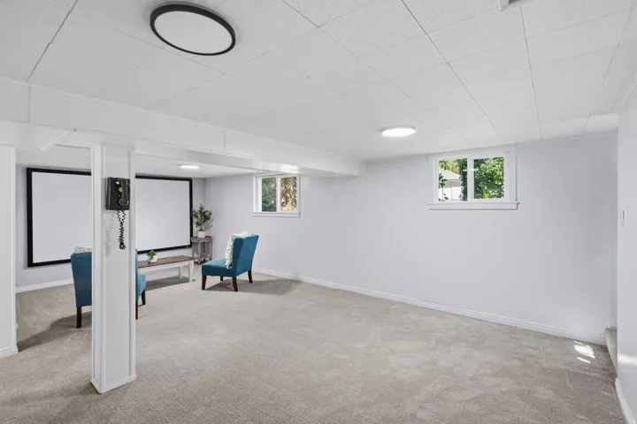 Recessed lighting, light-toned carpeting, two windows, and white walls