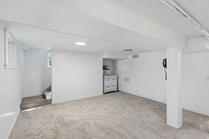 Carpeted flooring, recessed lighting, white walls, built-in cabinetry, and a window