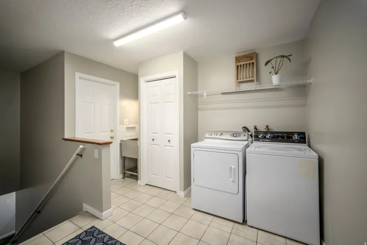 Utility area with tile flooring, a utility shelving