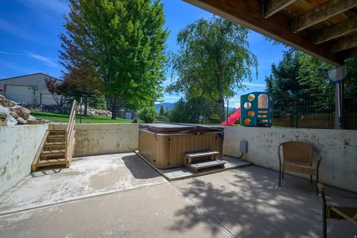 Poured concrete patio featuring a not included hot tub with steps