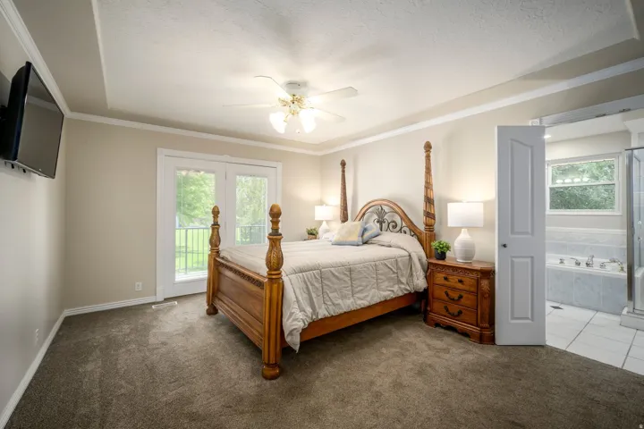 Plush carpeting and a tray ceiling with a ceiling fan