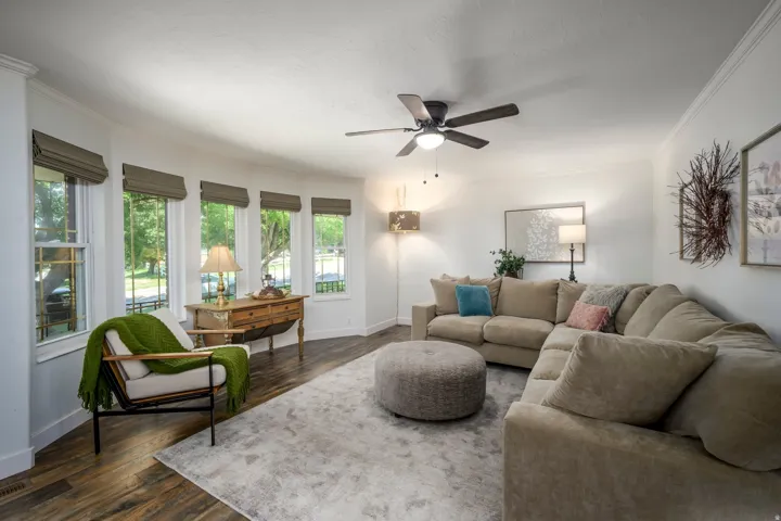 Recessed bay box windows  wood-finish flooring, molding, and a ceiling fan with integrated lighting