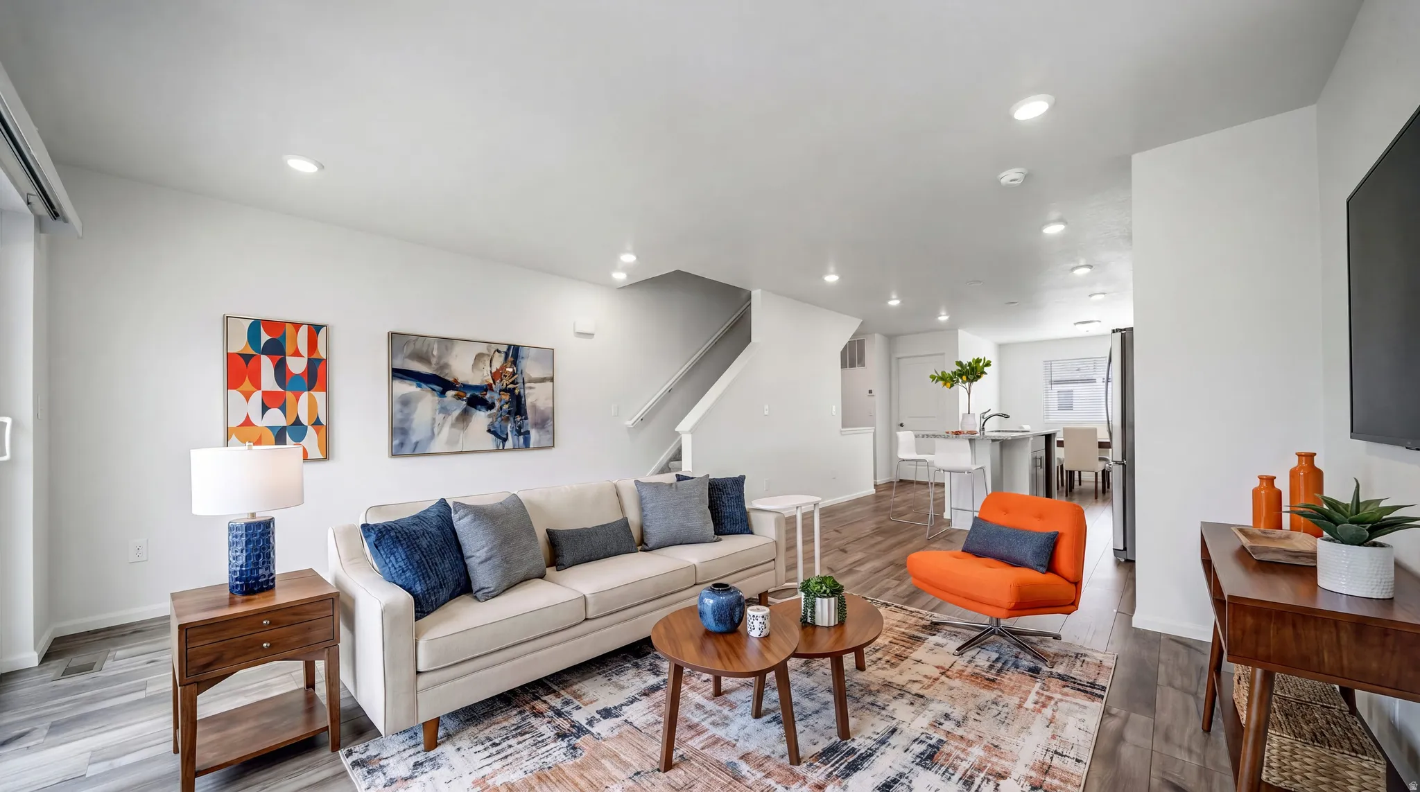 Expansive open-concept living area featuring recessed lighting, wood-finish flooring, and white walls