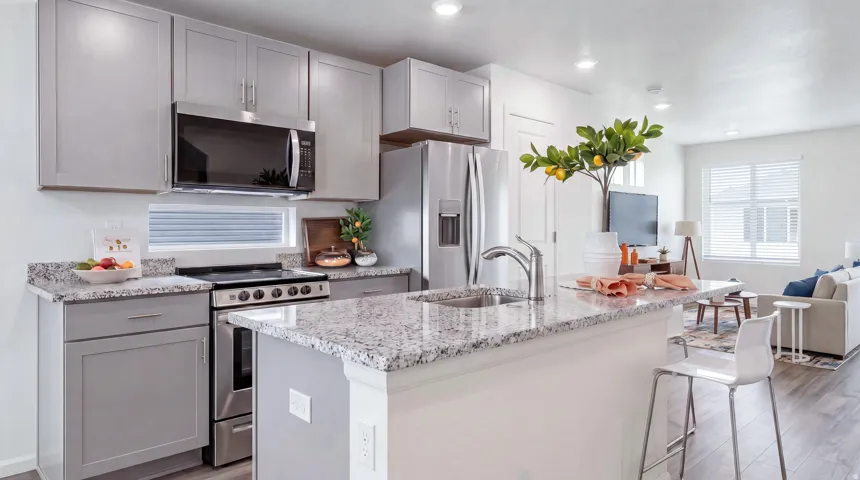 Kitchen featuring light gray cabinetry, stainless steel appliances, granite countertops, and wood-finish flooring
