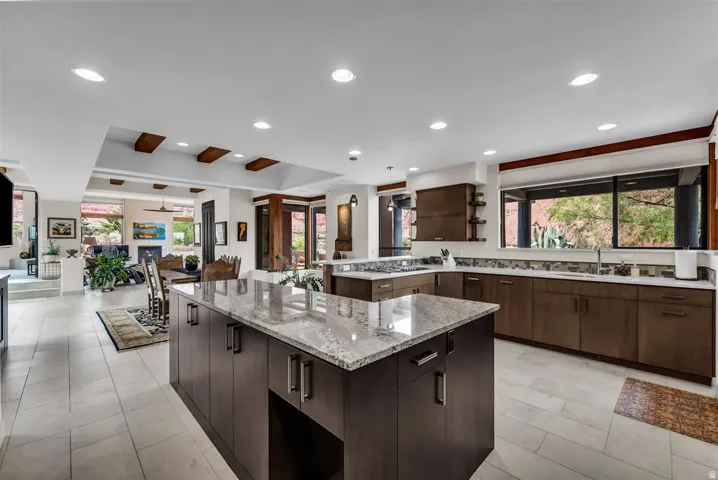 Gourmet kitchen with double islands, integrated cooktop, built-in double ovens, and a beverage cooler