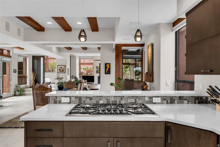 White countertop with an integrated gas cooktop, complemented by dark wood-finish cabinetry