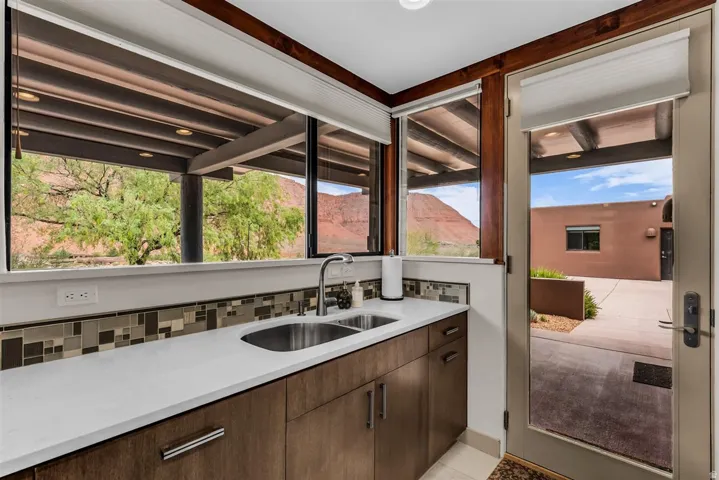 Wood-finish cabinetry with a white countertop and mosaic tile backsplash