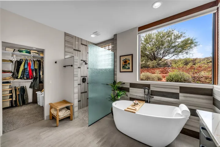 Primary Bathroom with dual vanity and soaking tub and walk in closet