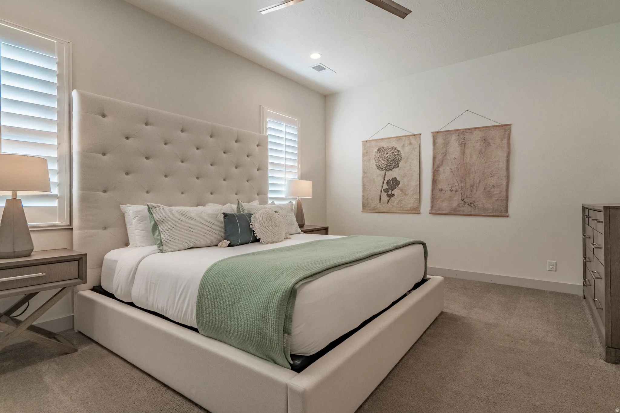 Main Floor Primary Bedroom with plush carpet flooring complementing a neutral wall palette