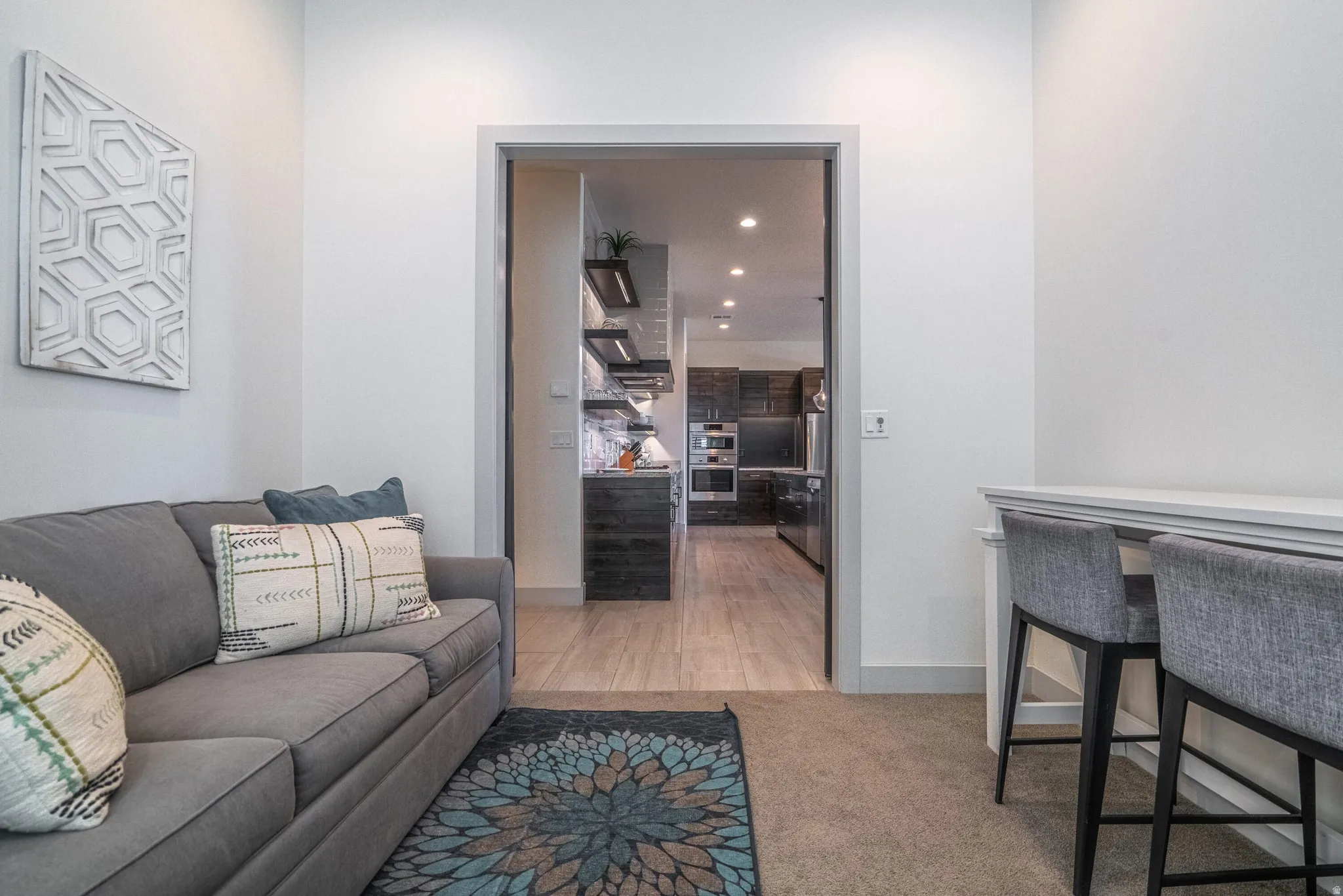 Recessed lighting, neutral wall tones, and carpeted flooring define this space