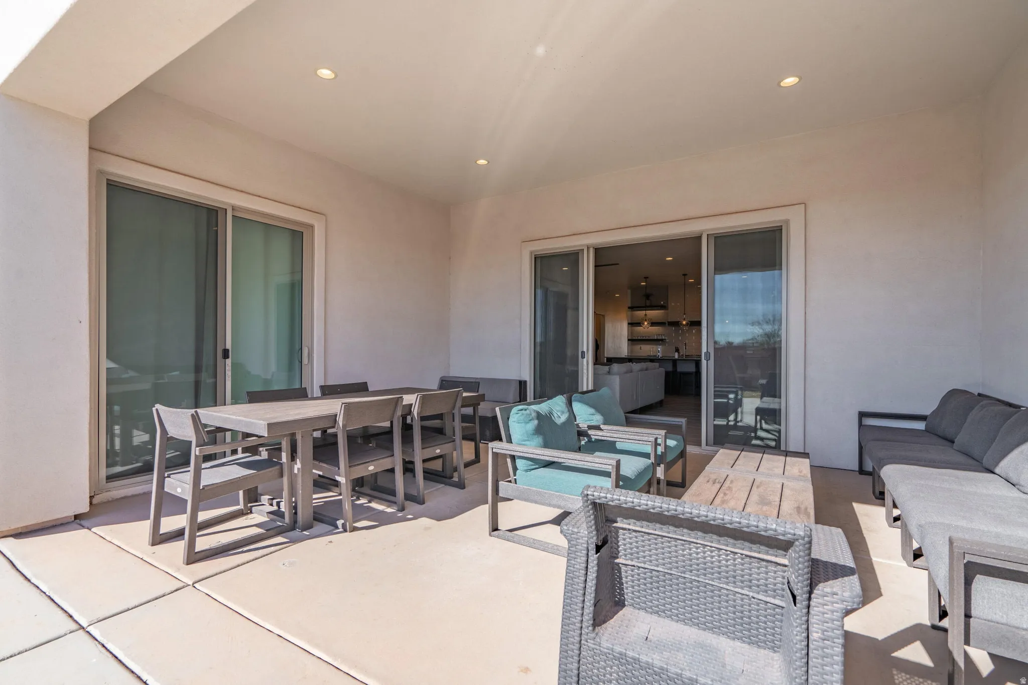 Covered patio featuring concrete flooring and two sets of sliding glass doors