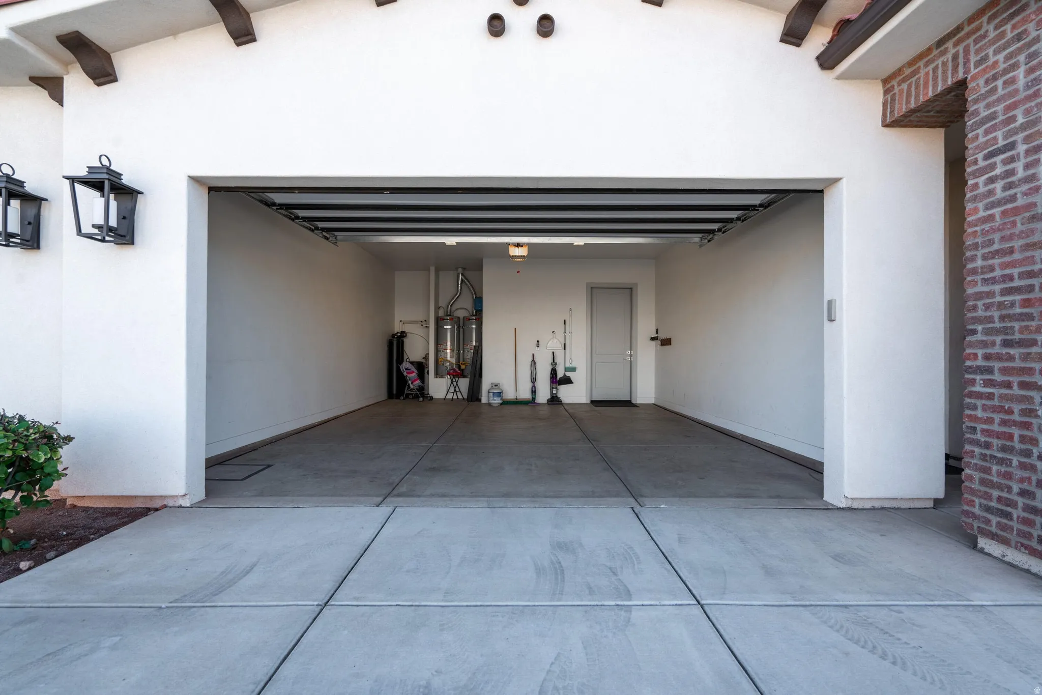 Spacious garage with a concrete floor, interior access door, and integrated lighting