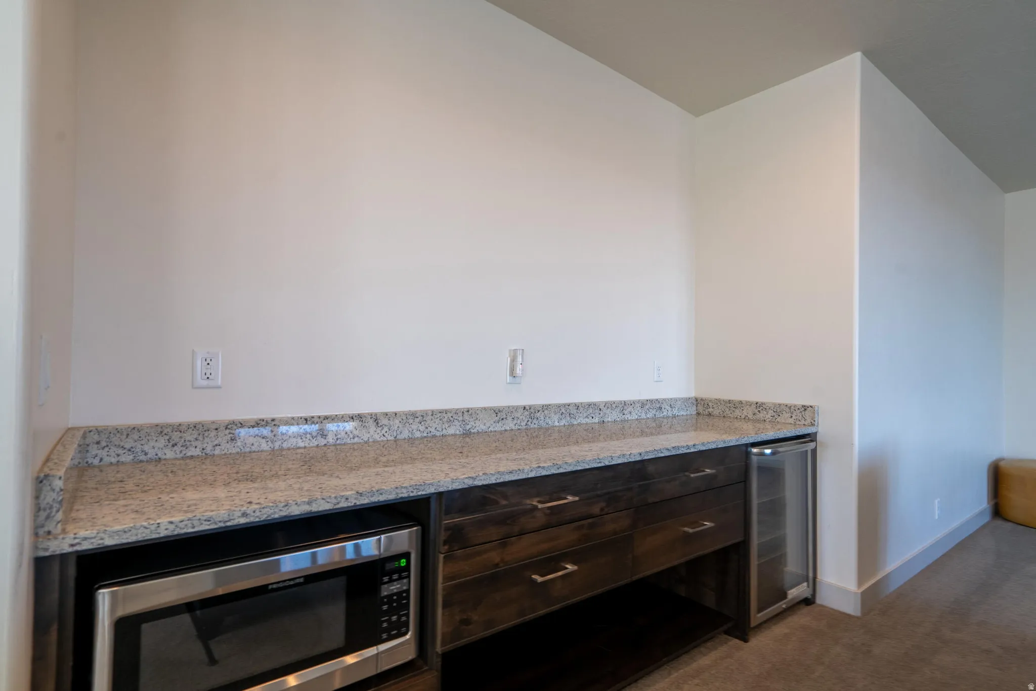 In 2nd Floor Family Room Built-in microwave, beverage refrigerator, dark wood-finish cabinetry, light-toned countertop
