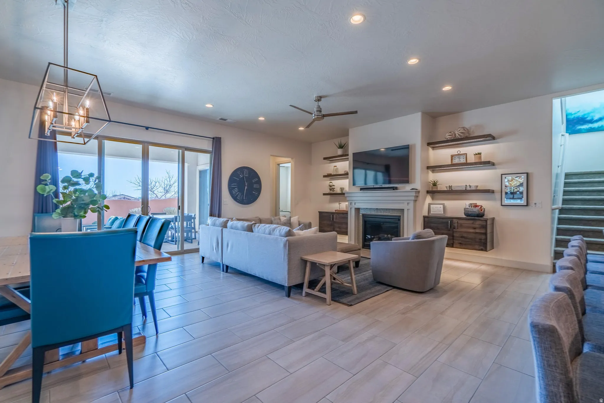 Open-concept living area with tile flooring, a fireplace, ceiling fan, recessed lighting, and sliding glass doors