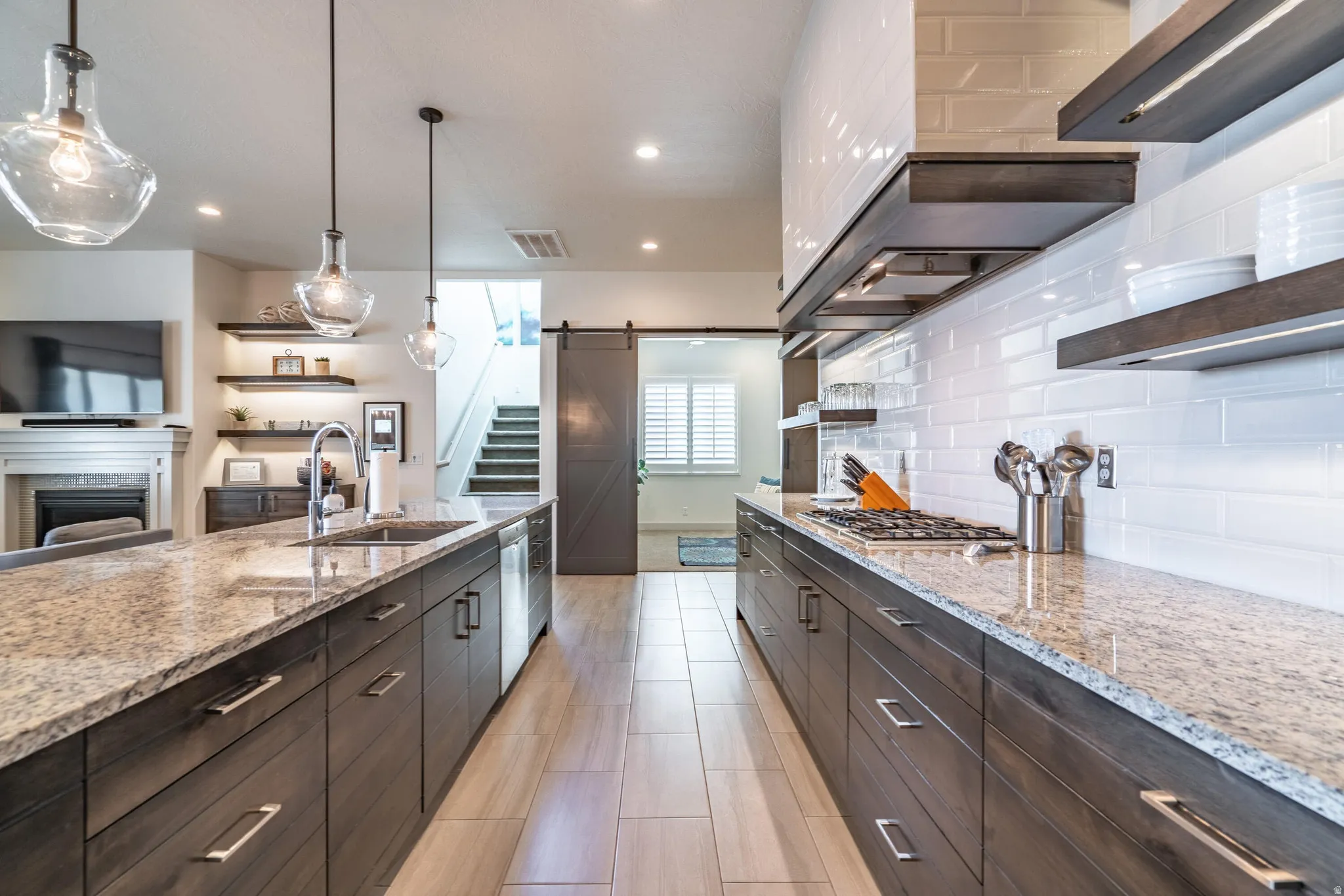 Kitchen featuring granite countertops, wood-finish cabinetry, a gas cooktop, and a subway tile backsplash