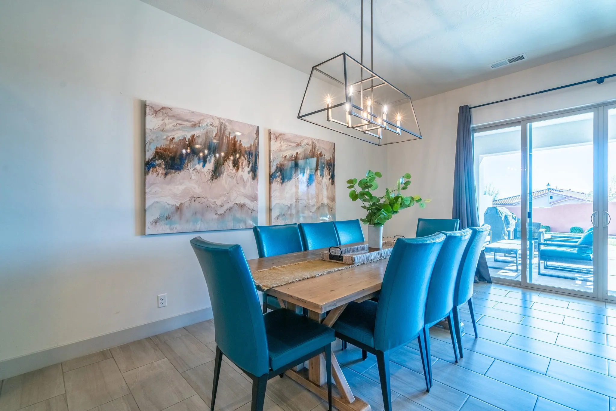 Tile flooring, modern linear chandelier, and sliding glass door to outdoor living space