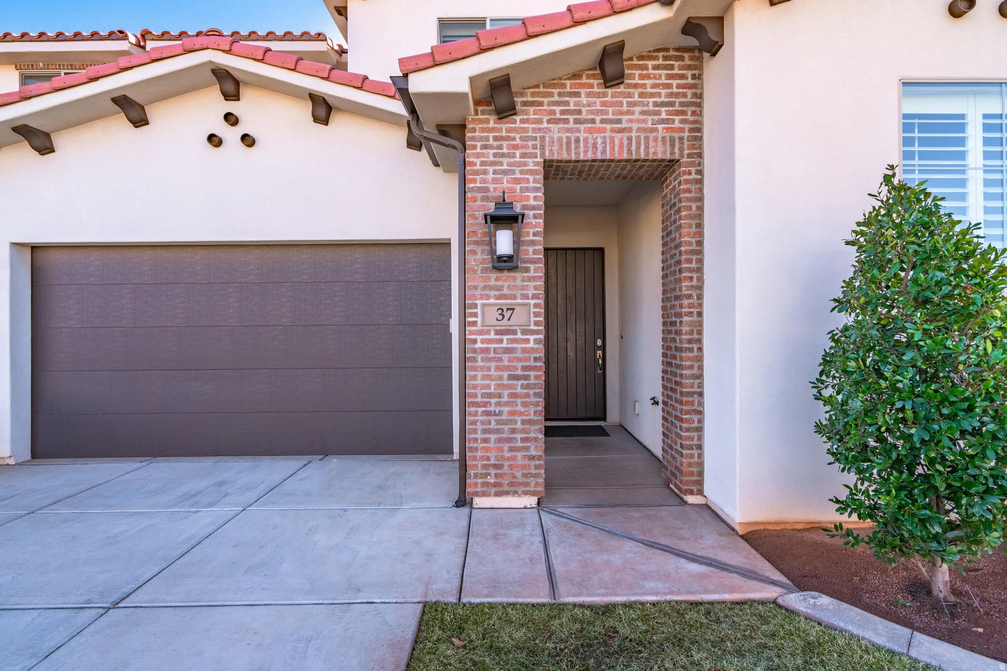 Stucco exterior with brick accents and red roof tiles
