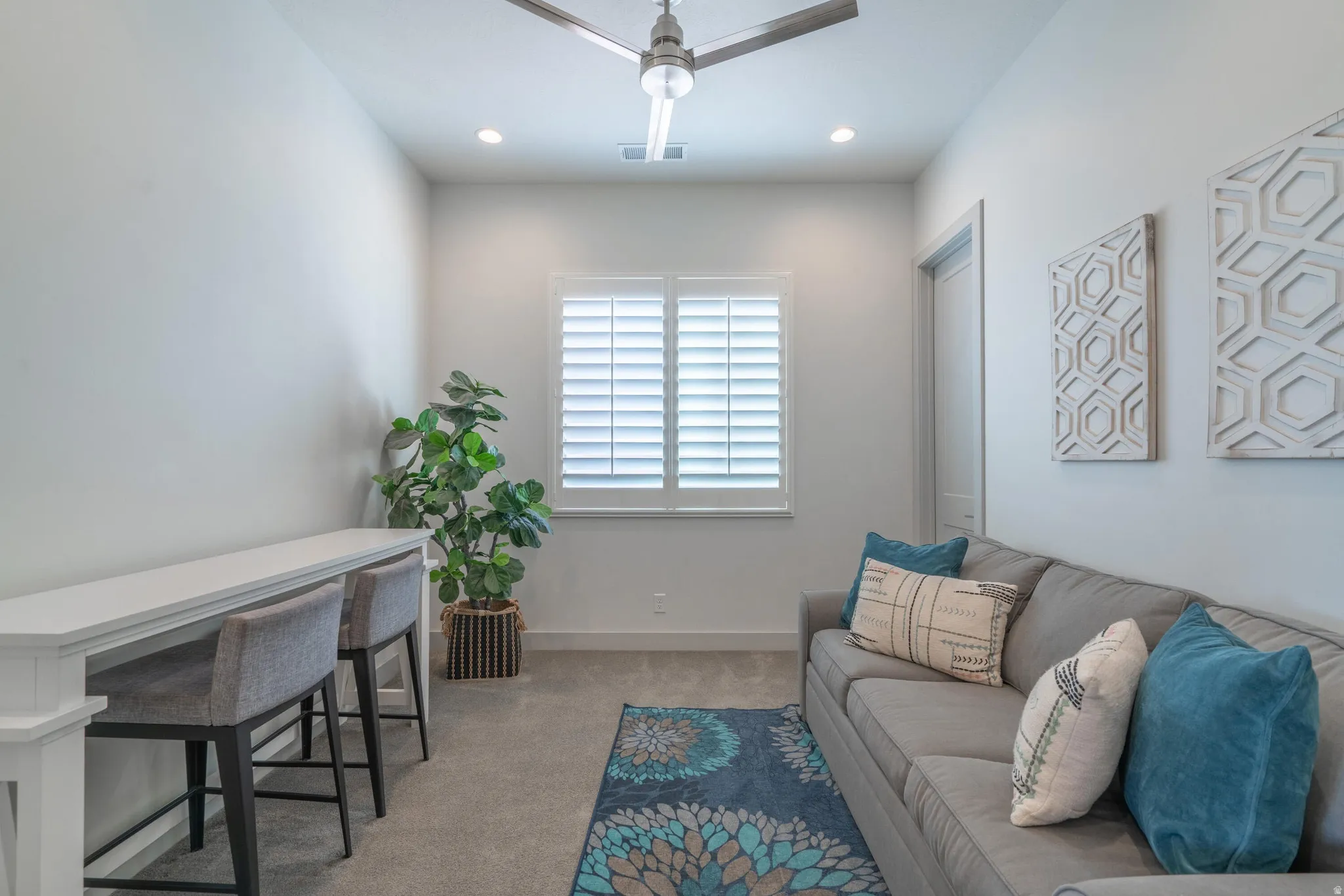 Window with plantation shutters, overhead recessed lighting, and a ceiling fan