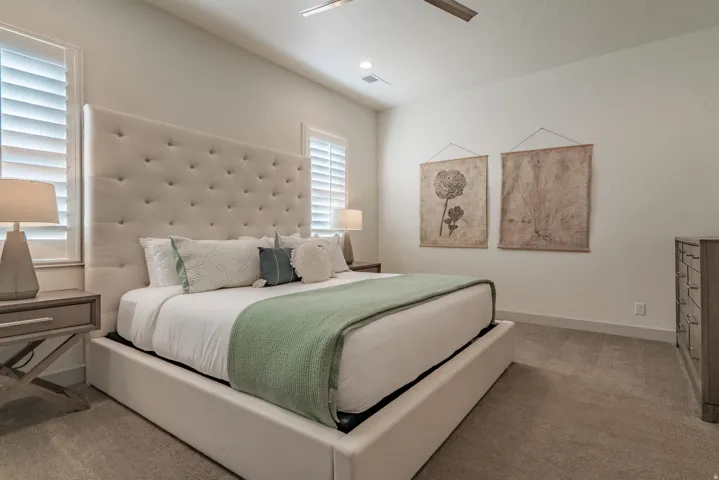 Main Floor Primary Bedroom with plush carpet flooring complementing a neutral wall palette