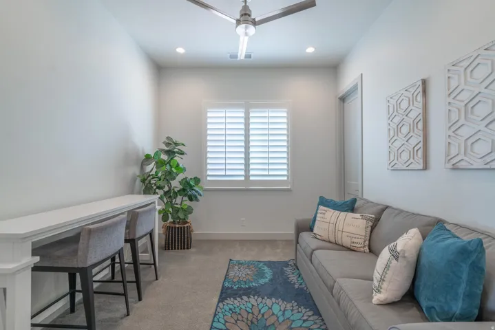 Window with plantation shutters, overhead recessed lighting, and a ceiling fan