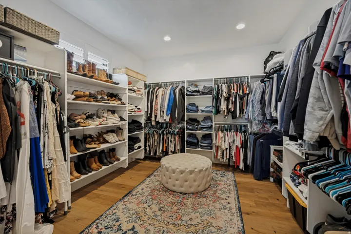 Expansive walk-in closet featuring wood-finish flooring and integrated shelving