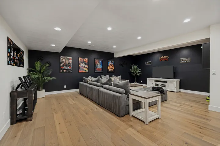 Recessed lighting illuminates the spacious room with wood-finish flooring