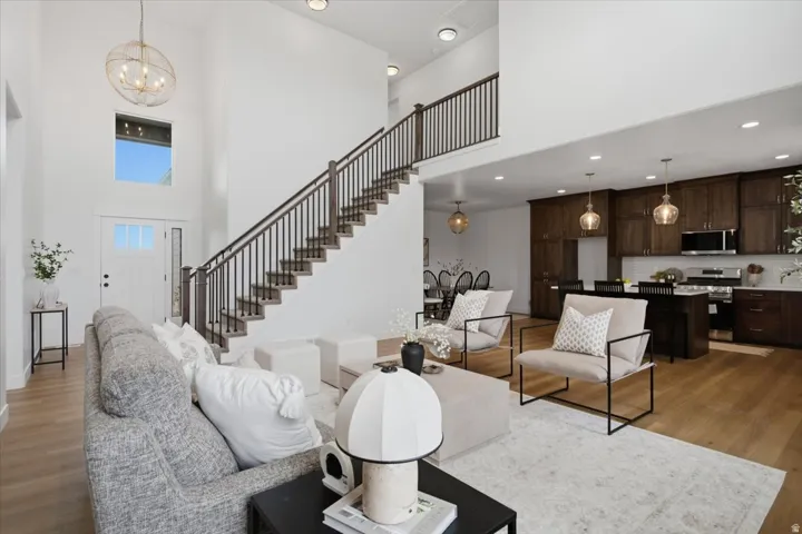 Two-story entry with a decorative chandelier, open staircase with dark balusters, and wood-finish flooring